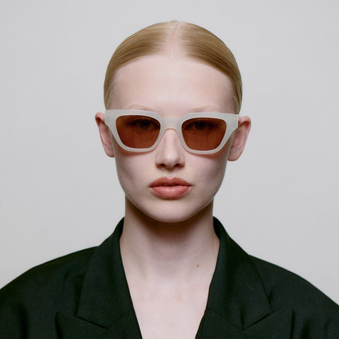 Frauen Model trägt A.Kjærbede Sonnenbrille Kaws KL2310 in der Farbe Cream Bone