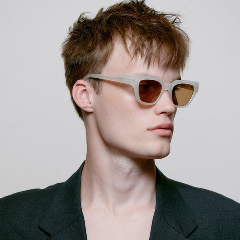 Männer Model trägt A.Kjærbede Sonnenbrille Kaws KL2310 in der Farbe Cream Bone